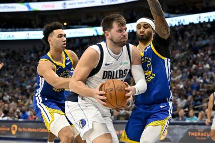Mar 13, 2024; Dallas, Texas, USA; Dallas Mavericks guard Luka Doncic (77) drives to the basket past Golden State Warriors forward Trayce Jackson-Davis (32) and guard Gary Payton II (0) during the first half at the American Airlines Center. Mandatory Credit: Jerome Miron-USA TODAY Sports
