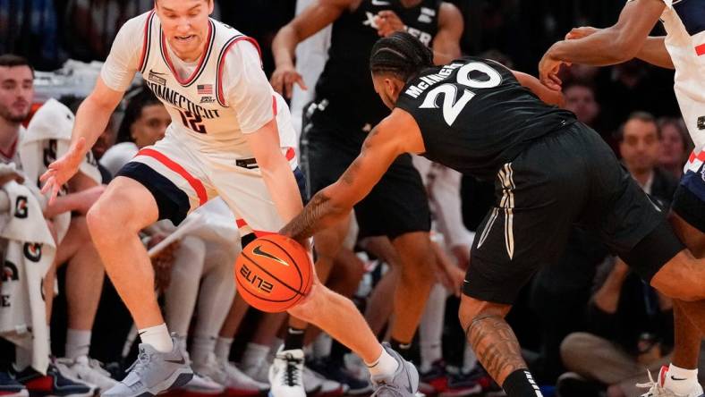 Mar 14, 2024; New York City, NY, USA;  Connecticut Huskies guard Cam Spencer (12) steals the ball from Xavier Musketeers guard Dayvion McKnight (20) during the first half at Madison Square Garden. Mandatory Credit: Robert Deutsch-USA TODAY Sports