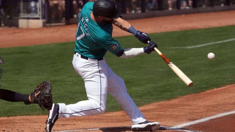 Mar 14, 2024; Peoria, Arizona, USA; Seattle Mariners left fielder Mitch Haniger (17) hits a solo home run against the Milwaukee Brewers during the first inning at Peoria Sports Complex. Mandatory Credit: Joe Camporeale-USA TODAY Sports