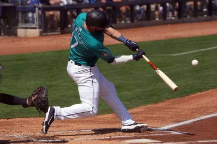 Mar 14, 2024; Peoria, Arizona, USA; Seattle Mariners left fielder Mitch Haniger (17) hits a solo home run against the Milwaukee Brewers during the first inning at Peoria Sports Complex. Mandatory Credit: Joe Camporeale-USA TODAY Sports