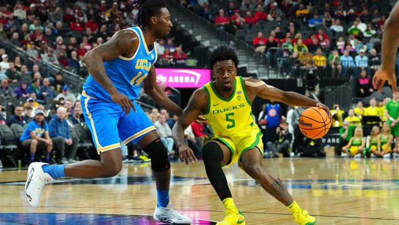 Mar 14, 2024; Las Vegas, NV, USA;Oregon Ducks guard Jermaine Couisnard (5) dribbles against UCLA Bruins forward Kenneth Nwuba (14) during the first half at T-Mobile Arena. Mandatory Credit: Stephen R. Sylvanie-USA TODAY Sports