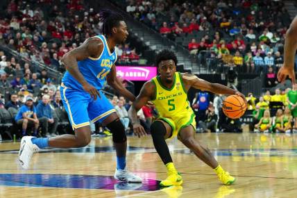 Mar 14, 2024; Las Vegas, NV, USA;Oregon Ducks guard Jermaine Couisnard (5) dribbles against UCLA Bruins forward Kenneth Nwuba (14) during the first half at T-Mobile Arena. Mandatory Credit: Stephen R. Sylvanie-USA TODAY Sports