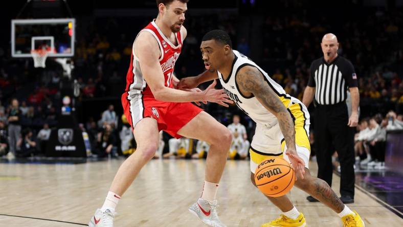 Mar 14, 2024; Minneapolis, MN, USA; Iowa Hawkeyes guard Tony Perkins (11) dribbles around Ohio State Buckeyes forward Jamison Battle (10) during the first half at Target Center. Mandatory Credit: Matt Krohn-USA TODAY Sports