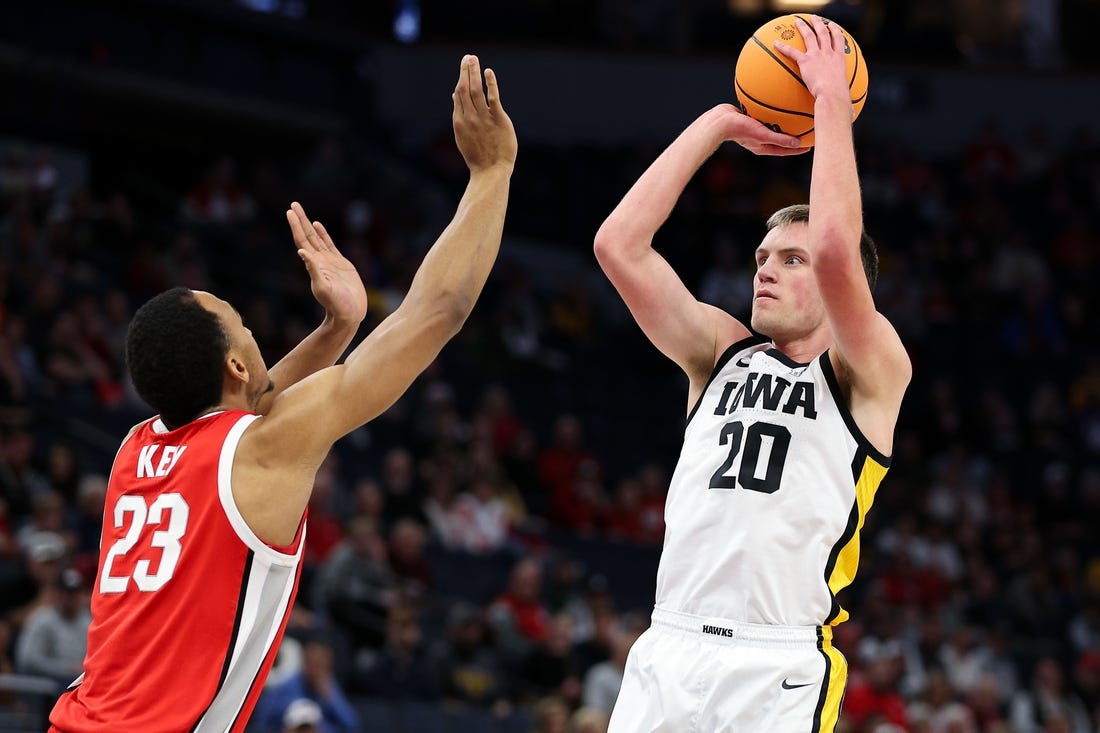 Mar 14, 2024; Minneapolis, MN, USA; Iowa Hawkeyes forward Payton Sandfort (20) shoots as Ohio State Buckeyes forward Zed Key (23) defends during the first half at Target Center. Mandatory Credit: Matt Krohn-USA TODAY Sports