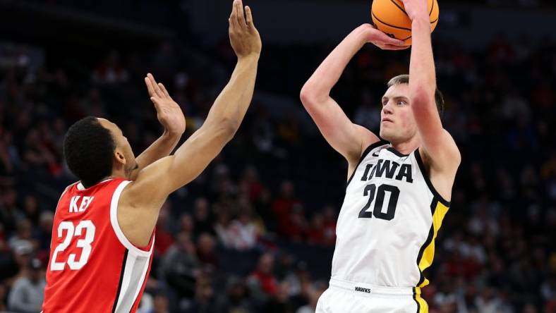 Mar 14, 2024; Minneapolis, MN, USA; Iowa Hawkeyes forward Payton Sandfort (20) shoots as Ohio State Buckeyes forward Zed Key (23) defends during the first half at Target Center. Mandatory Credit: Matt Krohn-USA TODAY Sports