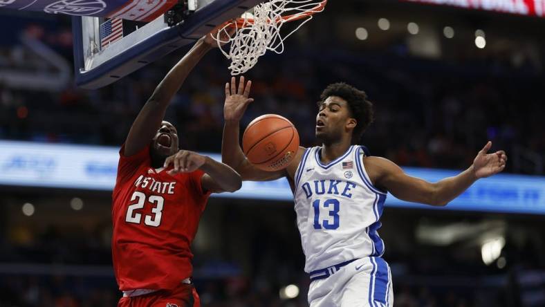 Mar 14, 2024; Washington, D.C., USA; North Carolina State forward Mohamed Diarra (23) dunks the ball as Duke Blue Devils forward Sean Stewart (13) defends in the first half at Capital One Arena. Mandatory Credit: Geoff Burke-USA TODAY Sports