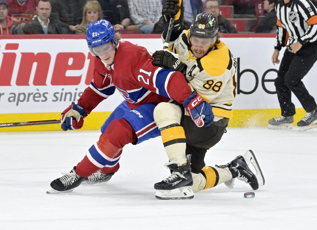 Mar 14, 2024; Montreal, Quebec, CAN; Montreal Canadiens defenseman Kaiden Guhle (21) checks Boston Bruins forward David Pastrnak (88) during the first period at the Bell Centre. Mandatory Credit: Eric Bolte-USA TODAY Sports