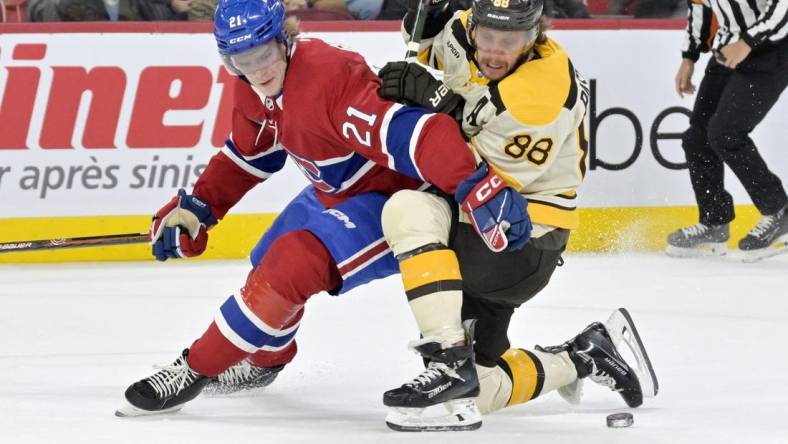 Mar 14, 2024; Montreal, Quebec, CAN; Montreal Canadiens defenseman Kaiden Guhle (21) checks Boston Bruins forward David Pastrnak (88) during the first period at the Bell Centre. Mandatory Credit: Eric Bolte-USA TODAY Sports