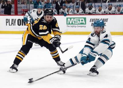 Mar 14, 2024; Pittsburgh, Pennsylvania, USA; San Jose Sharks defenseman Kyle Burroughs (4) defends Pittsburgh Penguins right wing Emil Bemstrom (52) during the first period at PPG Paints Arena. Mandatory Credit: Charles LeClaire-USA TODAY Sports