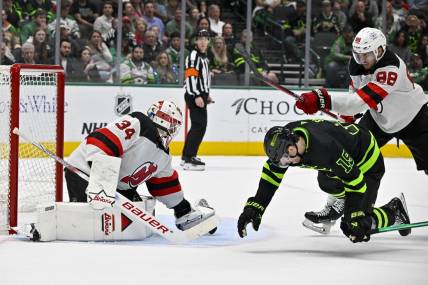 Mar 14, 2024; Dallas, Texas, USA; New Jersey Devils defenseman Kevin Bahl (88) is called for a cross check on Dallas Stars left wing Jamie Benn (14) as goaltender Jake Allen (34) covers the puck during the second period at the American Airlines Center. Mandatory Credit: Jerome Miron-USA TODAY Sports
