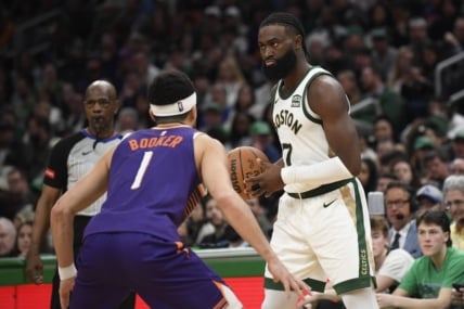 Mar 14, 2024; Boston, Massachusetts, USA;  Boston Celtics guard Jaylen Brown (7) controls the ball while Phoenix Suns guard Devin Booker (1) defends during the second half at TD Garden. Mandatory Credit: Bob DeChiara-USA TODAY Sports