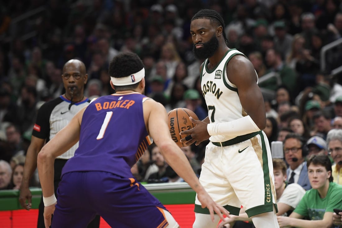 Mar 14, 2024; Boston, Massachusetts, USA;  Boston Celtics guard Jaylen Brown (7) controls the ball while Phoenix Suns guard Devin Booker (1) defends during the second half at TD Garden. Mandatory Credit: Bob DeChiara-USA TODAY Sports