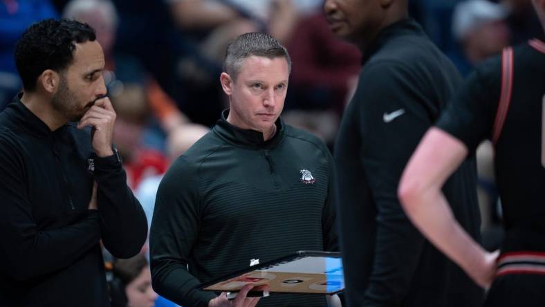 Georgia Bulldogs head coach Mike White confers with his coaches during their second round game of the SEC Men's Basketball Tournament against Florida at Bridgestone Arena in Nashville, Tenn., Thursday, March 14, 2024.