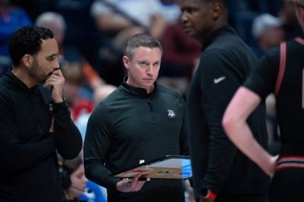 Georgia Bulldogs head coach Mike White confers with his coaches during their second round game of the SEC Men's Basketball Tournament against Florida at Bridgestone Arena in Nashville, Tenn., Thursday, March 14, 2024.