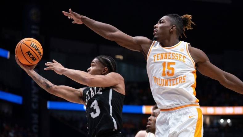 Mississippi State Bulldogs guard Shakeel Moore (3) eludes Tennessee Volunteers guard Jahmai Mashack (15) for a layup during their SEC Men's Basketball Tournament quarterfinal game at Bridgestone Arena in Nashville, Tenn., Friday, March 15, 2024.