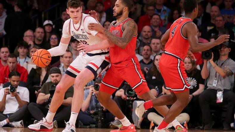 Mar 15, 2024; New York City, NY, USA; Connecticut Huskies center Donovan Clingan (32) controls the ball against St. John's Red Storm center Joel Soriano (11) and guard Nahiem Alleyne (4) during the first half at Madison Square Garden. Mandatory Credit: Brad Penner-USA TODAY Sports