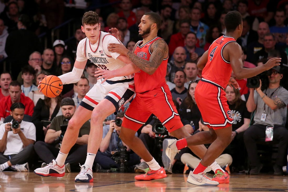 Mar 15, 2024; New York City, NY, USA; Connecticut Huskies center Donovan Clingan (32) controls the ball against St. John's Red Storm center Joel Soriano (11) and guard Nahiem Alleyne (4) during the first half at Madison Square Garden. Mandatory Credit: Brad Penner-USA TODAY Sports
