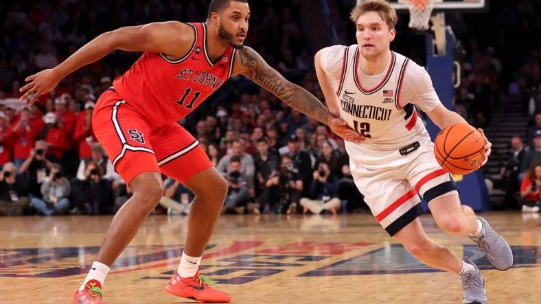 Mar 15, 2024; New York City, NY, USA; Connecticut Huskies guard Cam Spencer (12) drives to the basket against St. John's Red Storm center Joel Soriano (11) during the second half at Madison Square Garden. Mandatory Credit: Brad Penner-USA TODAY Sports