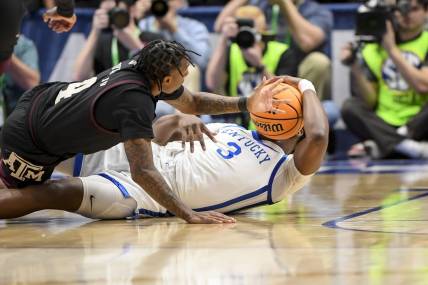 Mar 15, 2024; Nashville, TN, USA; Texas A&M Aggies guard Wade Taylor IV (4) and Kentucky Wildcats guard Adou Thiero (3) fight for the loose ball during the first half at Bridgestone Arena. Mandatory Credit: Steve Roberts-USA TODAY Sports