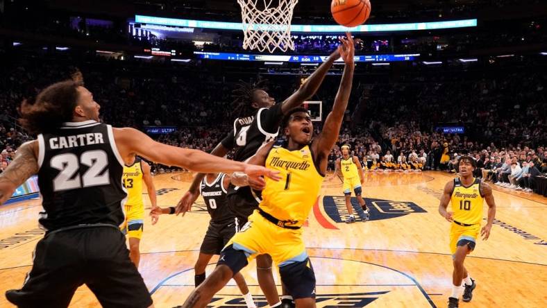 Mar 15, 2024; New York City, NY, USA;  Marquette Golden Eagles guard Kam Jones (1) shoots past Providence Friars guard Garwey Dual (3) during the first half at Madison Square Garden. Mandatory Credit: Robert Deutsch-USA TODAY Sports