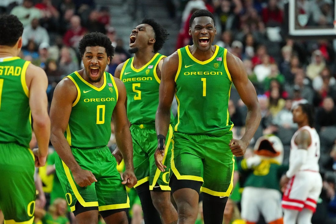 Mar 15, 2024; Las Vegas, NV, USA; Oregon Ducks center N'Faly Dante (1) celebrates with Oregon Ducks guard Kario Oquendo (0), and Oregon Ducks guard Jermaine Couisnard (5) after making a play against the Arizona Wildcats during the second half at T-Mobile Arena. Mandatory Credit: Stephen R. Sylvanie-USA TODAY Sports