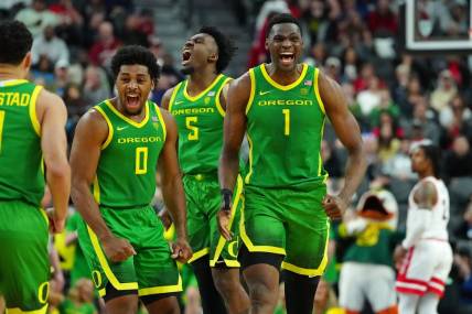Mar 15, 2024; Las Vegas, NV, USA; Oregon Ducks center N'Faly Dante (1) celebrates with Oregon Ducks guard Kario Oquendo (0), and Oregon Ducks guard Jermaine Couisnard (5) after making a play against the Arizona Wildcats during the second half at T-Mobile Arena. Mandatory Credit: Stephen R. Sylvanie-USA TODAY Sports