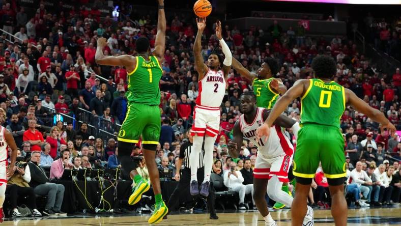 Mar 15, 2024; Las Vegas, NV, USA; Arizona Wildcats guard Caleb Love (2) shoots between Oregon Ducks center N'Faly Dante (1) and Oregon Ducks guard Jermaine Couisnard (5) during the second half at T-Mobile Arena. Mandatory Credit: Stephen R. Sylvanie-USA TODAY Sports