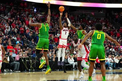 Mar 15, 2024; Las Vegas, NV, USA; Arizona Wildcats guard Caleb Love (2) shoots between Oregon Ducks center N'Faly Dante (1) and Oregon Ducks guard Jermaine Couisnard (5) during the second half at T-Mobile Arena. Mandatory Credit: Stephen R. Sylvanie-USA TODAY Sports