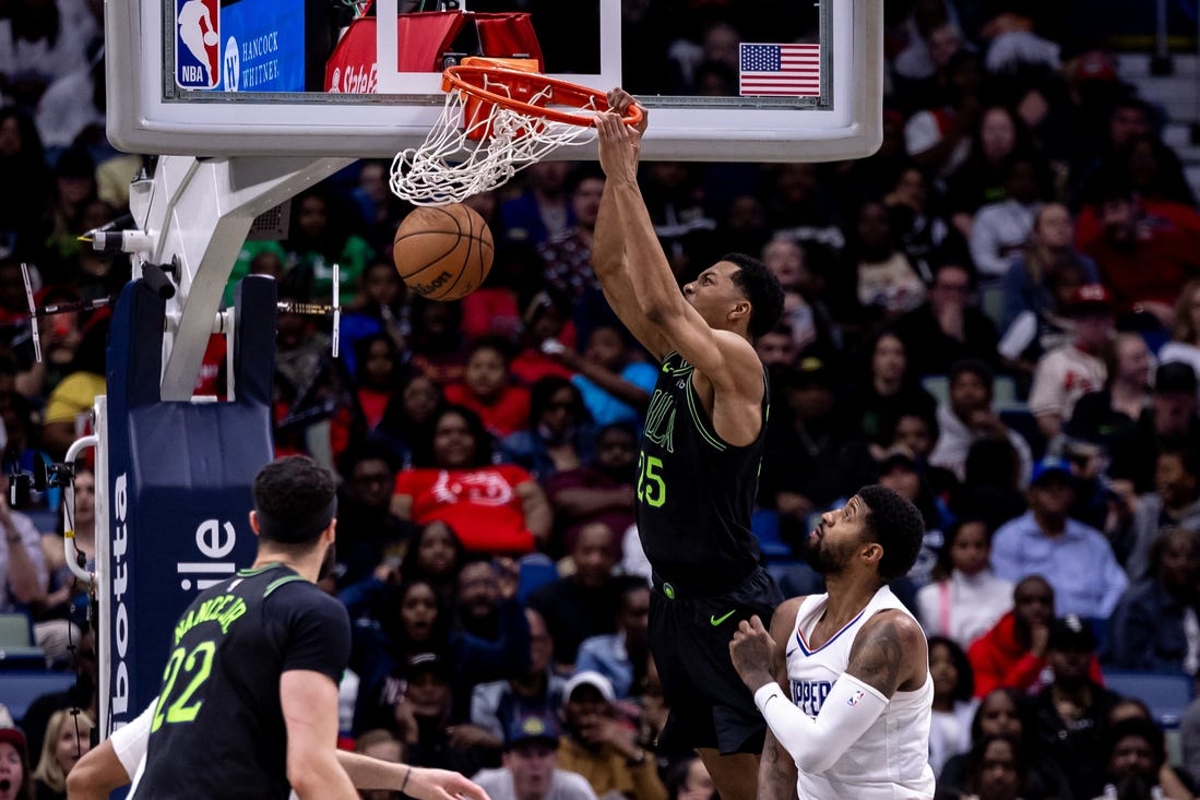 Mar 15, 2024; New Orleans, Louisiana, USA;  New Orleans Pelicans guard Trey Murphy III (25) dunks the ball against LA Clippers forward Paul George (13) during the second half at Smoothie King Center. Mandatory Credit: Stephen Lew-USA TODAY Sports