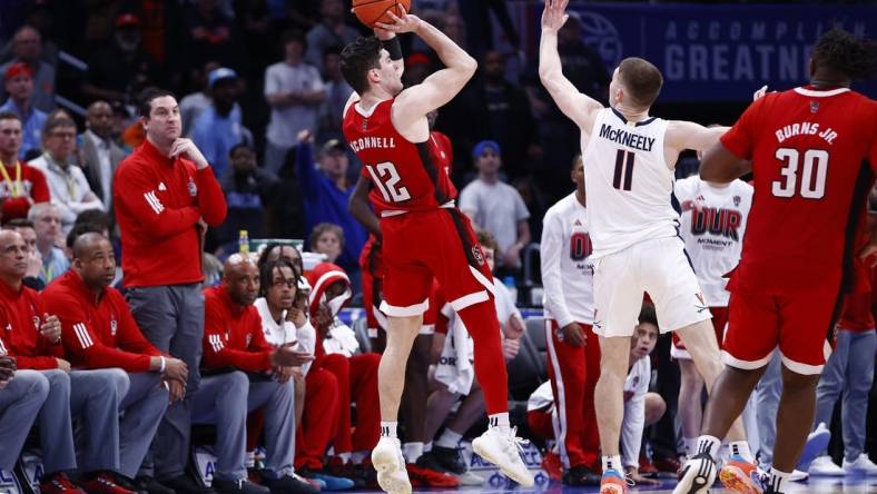 Mar 15, 2024; Washington, D.C., USA; North Carolina State Wolfpack guard Michael O'Connell (12) shoots a three point shot over Virginia Cavaliers guard Isaac McKneely (11) at the buzzer during the second half at Capital One Arena. Mandatory Credit: Amber Searls-USA TODAY Sports