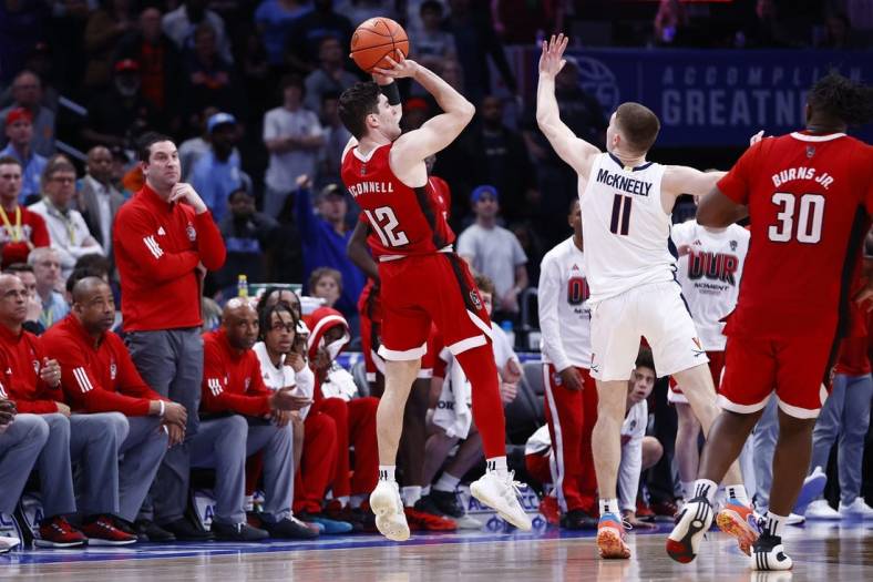 Mar 15, 2024; Washington, D.C., USA; North Carolina State Wolfpack guard Michael O'Connell (12) shoots a three point shot over Virginia Cavaliers guard Isaac McKneely (11) at the buzzer during the second half at Capital One Arena. Mandatory Credit: Amber Searls-USA TODAY Sports