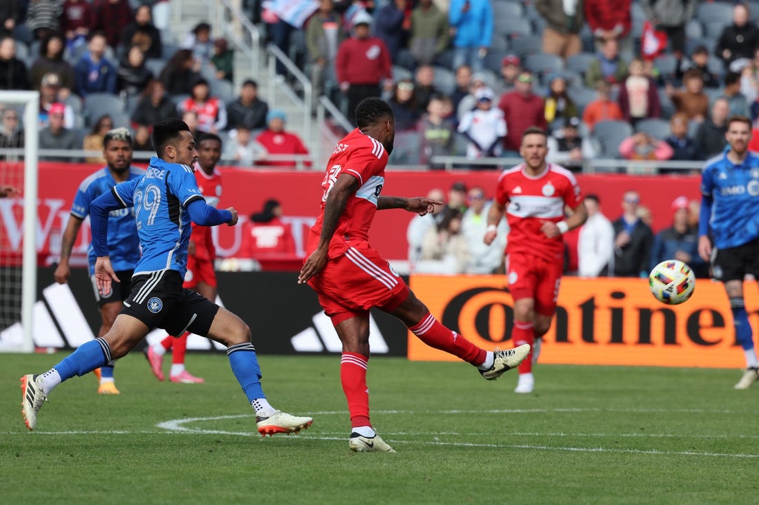 Mar 16, 2024; Chicago, Illinois, USA; Chicago Fire FC midfielder Kellyn Acosta (23) kicks the ball against CF Montreal midfielder Mathieu Choiniere (29) to score a long goal during the second half at Soldier Field. Mandatory Credit: Mike Dinovo-USA TODAY Sports