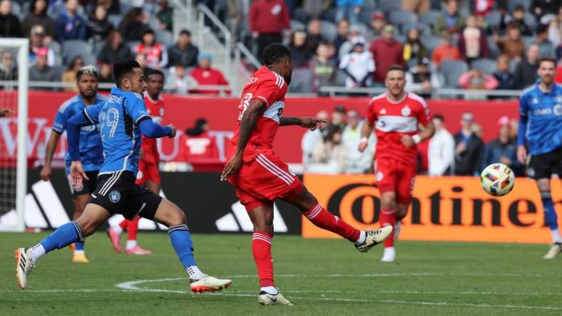 Mar 16, 2024; Chicago, Illinois, USA; Chicago Fire FC midfielder Kellyn Acosta (23) kicks the ball against CF Montreal midfielder Mathieu Choiniere (29) to score a long goal during the second half at Soldier Field. Mandatory Credit: Mike Dinovo-USA TODAY Sports