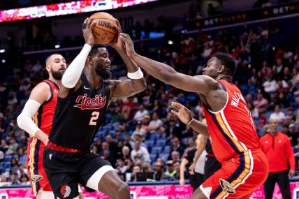 Mar 16, 2024; New Orleans, Louisiana, USA;  Portland Trail Blazers center Deandre Ayton (2) dribbles against New Orleans Pelicans forward Zion Williamson (1) during the first half at Smoothie King Center. Mandatory Credit: Stephen Lew-USA TODAY Sports