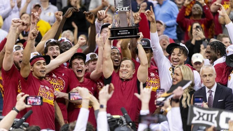 Mar 16, 2024; Kansas City, MO, USA; Iowa State Cyclones head coach TJ Otzelberger hoists the Big 12 Tournament trophy alongside his team after defeating the Houston Cougars at T-Mobile Center. Mandatory Credit: Amy Kontras-USA TODAY Sports