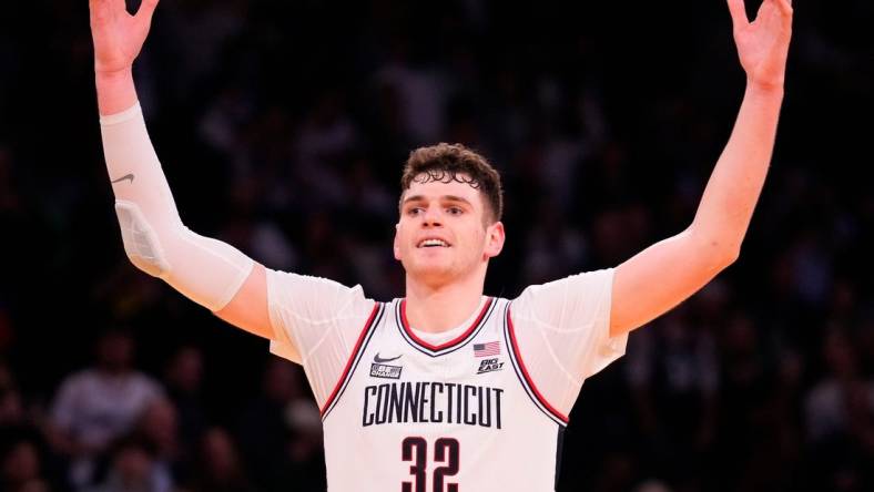 Mar 16, 2024; New York City, NY, USA;  Connecticut Huskies center Donovan Clingan (32) celebrates as the clock winds down against Marquette Golden Eagles in the second half at Madison Square Garden. Mandatory Credit: Robert Deutsch-USA TODAY Sports