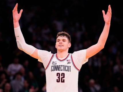 Mar 16, 2024; New York City, NY, USA;  Connecticut Huskies center Donovan Clingan (32) celebrates as the clock winds down against Marquette Golden Eagles in the second half at Madison Square Garden. Mandatory Credit: Robert Deutsch-USA TODAY Sports