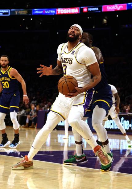 vMar 16, 2024; Los Angeles, California, USA; Los Angeles Lakers forward Anthony Davis (3) spins against Golden State Warriors forward Draymond Green (23) during the first quarter at Crypto.com Arena. Mandatory Credit: Jason Parkhurst-USA TODAY Sports