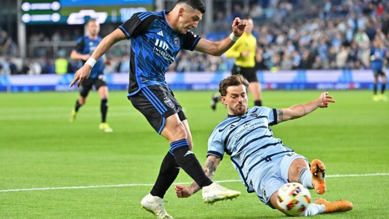 Mar 16, 2024; Kansas City, Kansas, USA; San Jose Earthquakes midfielder Cristian Espinoza (10) shoots the ball against Sporting Kansas City defender Tim Leibold (14) during the first half  at Children's Mercy Park. Mandatory Credit: Peter Aiken-USA TODAY Sports