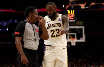 Mar 16, 2024; Los Angeles, California, USA; Los Angeles Lakers forward LeBron James (23) talks to referee Mitchell Ervin (27) during the second quarter against the Golden State Warriors at Crypto.com Arena. Mandatory Credit: Jason Parkhurst-USA TODAY Sports