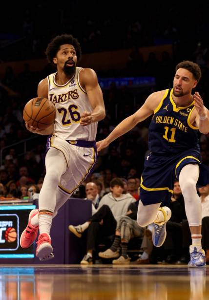 Mar 16, 2024; Los Angeles, California, USA; Los Angeles Lakers guard Spencer Dinwiddie (26) drives against Golden State Warriors guard Klay Thompson (11) during the second quarter at Crypto.com Arena. Mandatory Credit: Jason Parkhurst-USA TODAY Sports