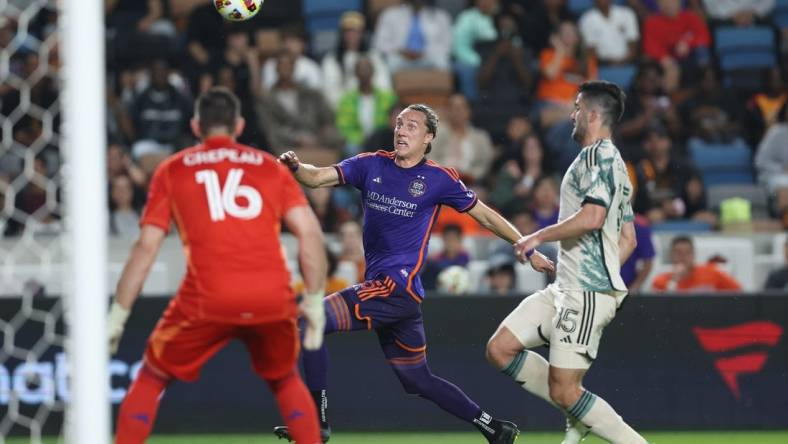 Mar 16, 2024; Houston, Texas, USA; Houston Dynamo FC midfielder Griffin Dorsey (25) runs after the ball against Portland Timbers defender Eric Miller (15) in the first half at Shell Energy Stadium. Mandatory Credit: Troy Taormina-USA TODAY Sports