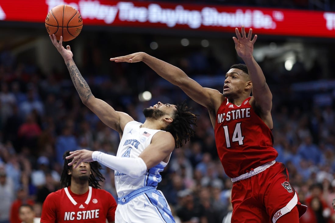 Mar 16, 2024; Washington, D.C., USA; North Carolina Tar Heels guard RJ Davis (4) shoots the ball against North Carolina State Wolfpack guard Casey Morsell (14) during the second half at Capital One Arena. Mandatory Credit: Geoff Burke-USA TODAY Sports