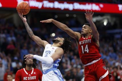 Mar 16, 2024; Washington, D.C., USA; North Carolina Tar Heels guard RJ Davis (4) shoots the ball against North Carolina State Wolfpack guard Casey Morsell (14) during the second half at Capital One Arena. Mandatory Credit: Geoff Burke-USA TODAY Sports