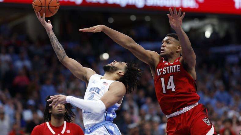 Mar 16, 2024; Washington, D.C., USA; North Carolina Tar Heels guard RJ Davis (4) shoots the ball against North Carolina State Wolfpack guard Casey Morsell (14) during the second half at Capital One Arena. Mandatory Credit: Geoff Burke-USA TODAY Sports