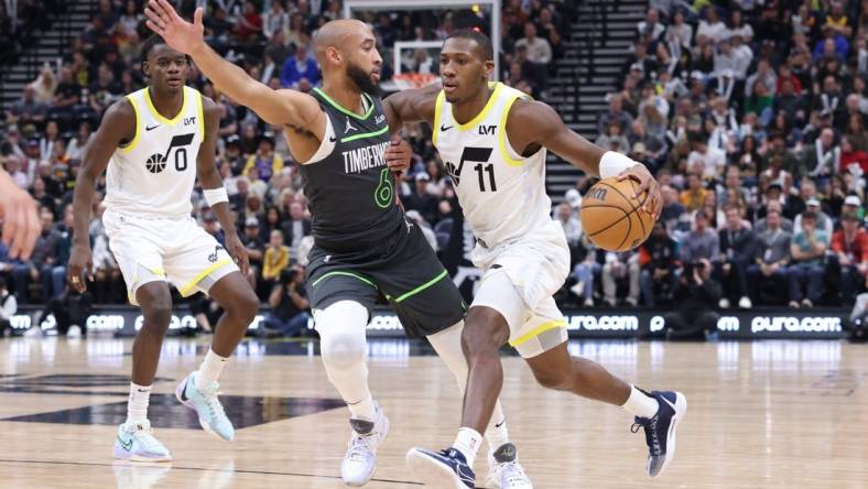 Mar 16, 2024; Salt Lake City, Utah, USA; Utah Jazz guard Kris Dunn (11) drives against Minnesota Timberwolves guard Jordan McLaughlin (6) during the second quarter at Delta Center. Mandatory Credit: Rob Gray-USA TODAY Sports