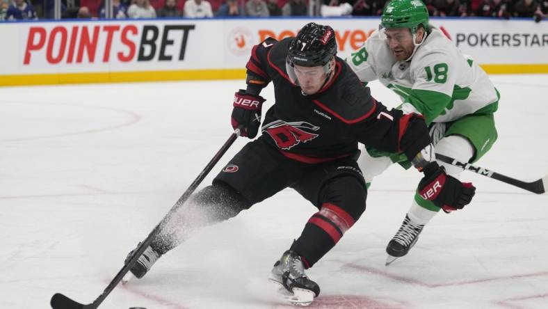 Mar 16, 2024; Toronto, Ontario, CAN; Carolina Hurricanes defenseman Dmitry Orlov (7) controls the puck against Toronto Maple Leafs forward Noah Gregor (18) during the third period at Scotiabank Arena. Mandatory Credit: John E. Sokolowski-USA TODAY Sports