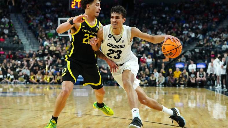 Mar 16, 2024; Las Vegas, NV, USA; Colorado Buffaloes forward Tristan da Silva (23) dribbles against Oregon Ducks guard Jadrian Tracey (22) during the first half at T-Mobile Arena. Mandatory Credit: Stephen R. Sylvanie-USA TODAY Sports