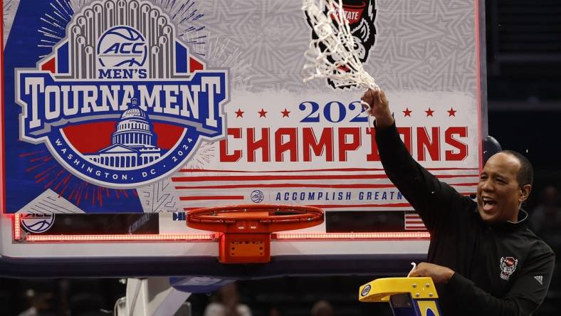 Mar 16, 2024; Washington, D.C., USA; North Carolina State Wolfpack head coach Kevin Keatts reacts by cutting the net from the basketball rim after defeating the North Carolina Tar Heels at Capital One Arena. Mandatory Credit: Geoff Burke-USA TODAY Sports