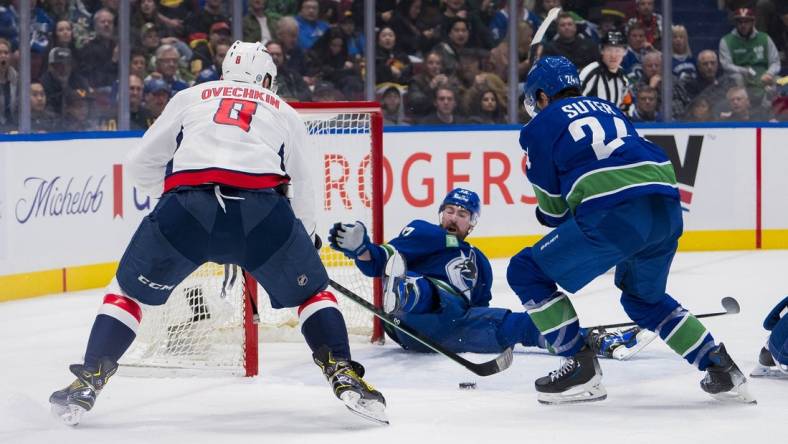 Mar 16, 2024; Vancouver, British Columbia, CAN; Vancouver Canucks defenseman Filip Hronek (17) and forward Pius Suter (24) watch as Washington Capitals forward Alex Ovechkin (8) scores on the Vancouver goal in the second period at Rogers Arena. Mandatory Credit: Bob Frid-USA TODAY Sports